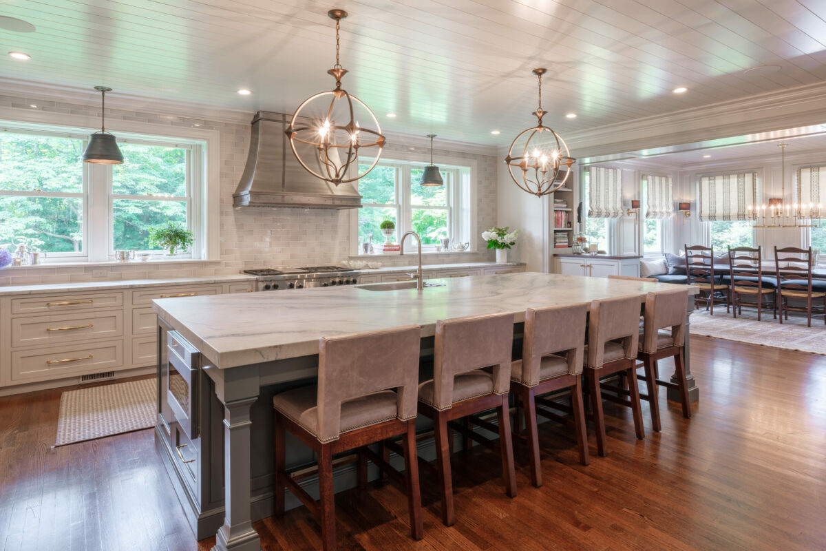 White kitchen cabinets with gray island and nickel gap ceiling boards with custom moulding from Tague Lumber